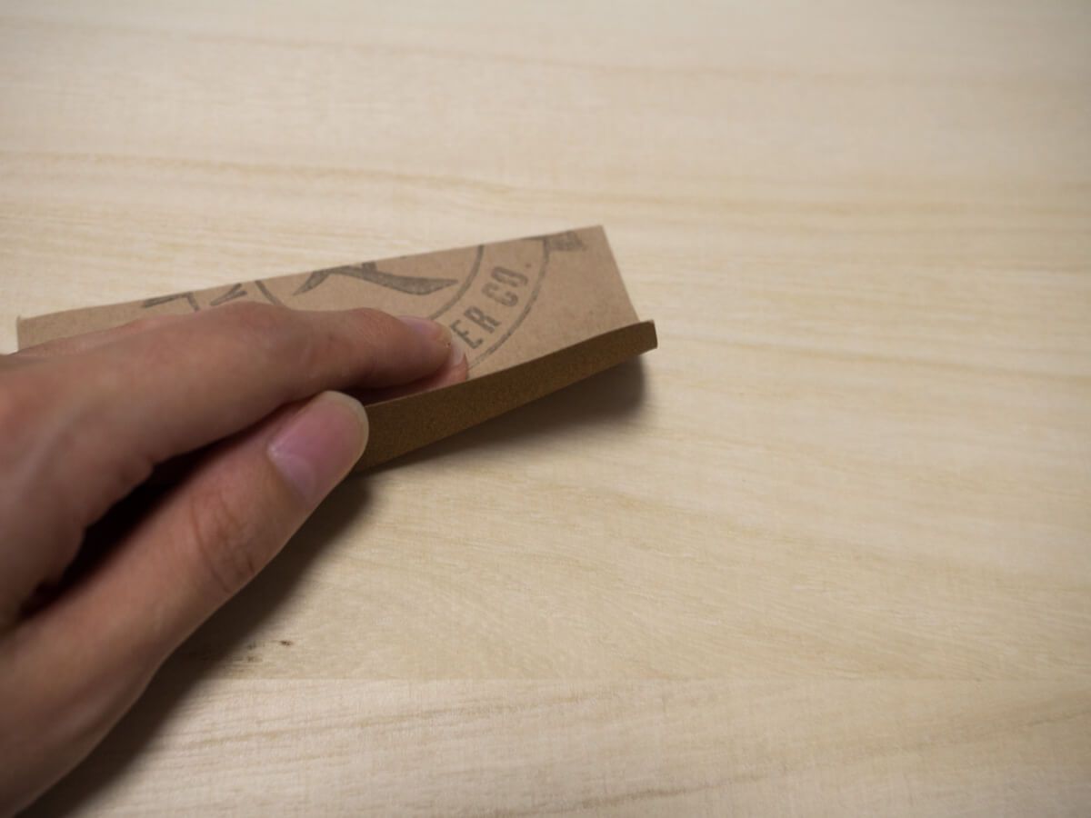 サイドテーブルの木材を紙やすりで削る